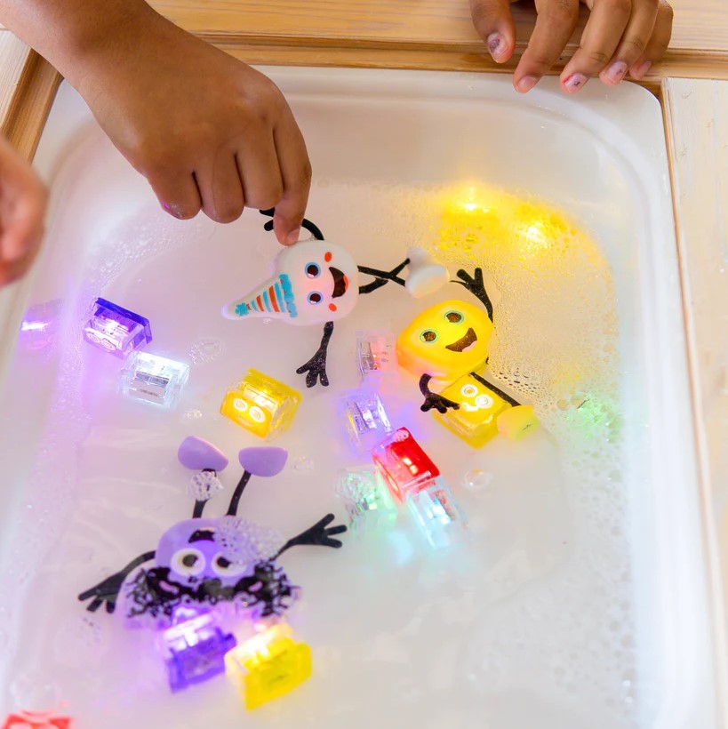 GLO PALS: Ein Mann und ein mehrfarbiger leuchtender sensorischer Würfel zum Water Party Kumpel leuchtet sensorisches Spielzeug