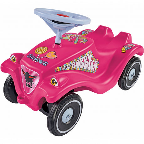 Różowy chodzik Big Bobby Car Candy z kierownicą i klaksonem, doskonały pchacz i jeździk zapewniający bezpieczną zabawę.