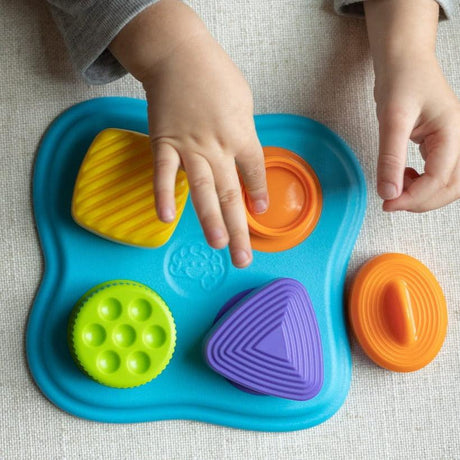 Zabawka sensoryczna edukacyjna Fat Brain Toys Lidzy z nakrętkami stymuluje rozwój dziecka poprzez manipulacyjne niespodzianki.