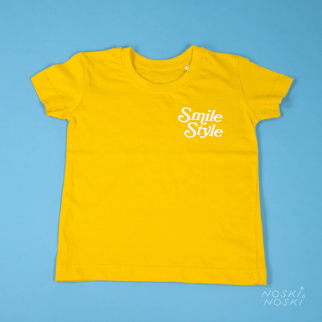 Soczyście żółta koszulka dla dzieci Noski Smile Style z napisem "Smile Style" i uśmiechniętym słońcem, wykonana z miękkiej bawełny