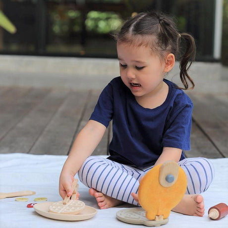 Drewniana gofrownica dla dzieci Plantoys z goframi i szczypcami, idealna do kącika Montessori.